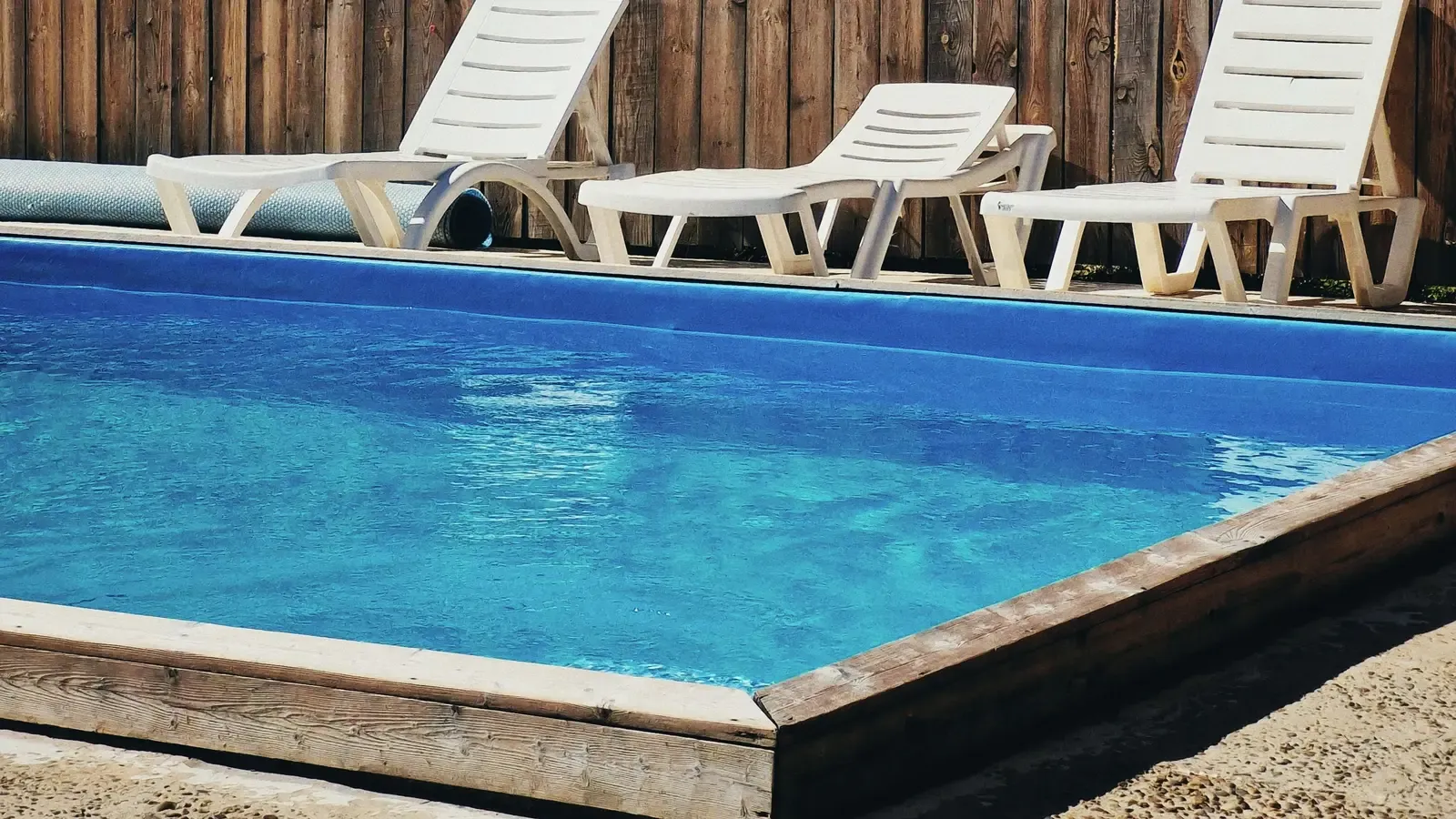 Piscina de chalet con el agua limpia y las hamacas al sol, en el Camp de Túria